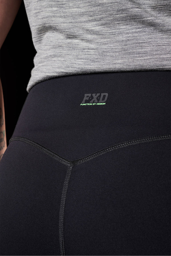 Black athletic leggings with EXD logo worn by a person, focusing on the waist area.